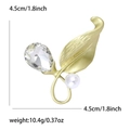 Matte goldene Blatbrosche mit geschliffenem Kristall und weißer Perle im Design - Mattgold