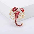 Squisita spilla a scorpione oro e rosso con dettagli in smalto su un supporto bianco - Base Oro Rosso