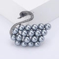 Elegant swan brooch with grey imitation pearls and dark grey crystals on white background - Gunmetal