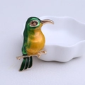 Exquisite Eisvogel-Brosche mit grüner und oranger Emaille auf goldenem Zweig - Grün