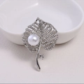 Elegant silver leaf brooch with sparkling crystals and a white pearl accent - Silver