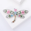 Vintage dragonfly brooch with colorful enamel wings and rhinestones on a white pedestal - Silver