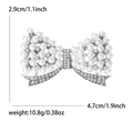 Elegant silver bow brooch with white pearls and rhinestones measuring 4.7cm in width - Silver