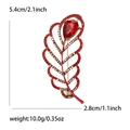 Elegante broche de pluma con cristales rojos, pedrería y dimensiones del accesorio - Rojo