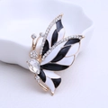 Elegante vlinderbroche met zwart-wit emaille en schitterende steentjes in goud - Zwart