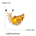 Lindo broche de caracol con esmalte naranja y brillantes diamantes en base dorada - Amarillo