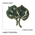 Luxurious green rhinestone leaf brooch in golden finish with vintage metal details - Green