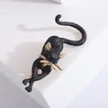 Spilla minimalista a forma di gatto nero in lega opaca con dettagli dorati e pietre verdi - Nero