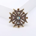 Spilla vintage a croce maltese dorata con cristalli marroni e strass AB su supporto bianco - Marrone