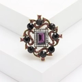 Dettaglio ravvicinato della spilla retrò con cristalli viola e strass neri - Viola