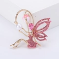 Broche fée élégante dorée avec strass roses et perle blanche sur fond blanc épuré - Rose
