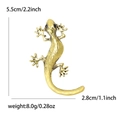 Golden gecko lizard brooch with black gemstone eyes and textured surface details - Gold