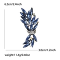 Detail view of crystal feather brooch with dimensions 6.2cm height and 3.0cm width - Blue