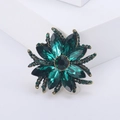 Close-up of green crystal floral brooch with vintage gold finish on white steps - Antique Gold Green 1025