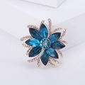 Elegant floral brooch with blue crystals and rose gold petals on a white pedestal - KC Gold Blue 1025