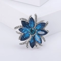 Macro detail of royal blue crystal flower brooch with silver floral micro-pave setting - White K Blue 1025