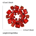 Elegant gold-tone circular brooch with red ruby-style crystals and detailed size labels - Red