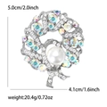 Vista de detalle del broche de corona redondo con diamantes y perlas, mide 5,0cm por 4,1cm - Plateado