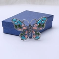 Detalle del broche de mariposa con alas de esmalte de colores y brillantes pedrería de cristal - Azul
