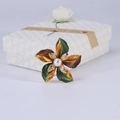 Dettaglio macro di elegante spilla a fiore con petali sfumati verdi e perla bianca - Verde