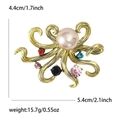Broche pieuvre dorée avec perle rose et strass colorés sur un fond blanc éclatant - Doré