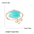 Broche masque créative en émail turquoise avec base dorée et strass transparents - Bleu