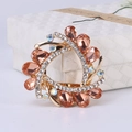 Broche de cristal champán con base de aleación dorada sobre una caja de regalo - café