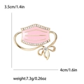 Broche masque en émail rose ornée de zircons brillants et d'un petit nœud doré - Rose