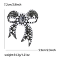 Detalle de las dimensiones 7,2 cm x 5,9 cm del broche de lazo con pedrería gris - Negro