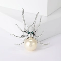 Retro spider brooch with large white pearl and green crystal eyes on a white base - White Style