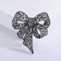 Vintage rhinestone bow brooch in antique silver finish with detailed hollow filigree design - Gun Black