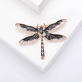 Elegante spilla a libellula dorata con ali in smalto e una gemma sfaccettata al centro - Nero
