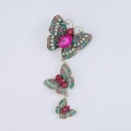 Dettaglio ravvicinato della spilla farfalla vintage a tre strati con strass colorati - Colorato