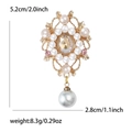 Vintage gold alloy flower brooch with rhinestones and pearl pendant measuring 5.2cm by 2.8cm - Gold