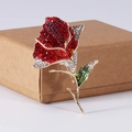 Detailansicht der eleganten Rosenbrosche mit funkelnden roten, weißen und grünen Kristallen - Rot