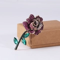 Elegant rose brooch with purple rhinestones and green crystals on vintage gold base - Purple