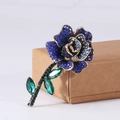 Elegant rose brooch with blue pavé crystals and emerald green leaves on gold metal - Blue