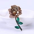 Elegant rose brooch with pink champagne rhinestones and green crystal leaves in gold finish - Brown