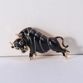 Detail of bull brooch showing black enamel finish and gold metallic outline on suit accessory - Black