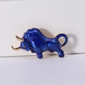 Macro shot of creative enamel bull brooch with deep blue finish and golden horns - Blue