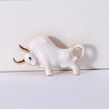 Detailed view of enamel bull brooch with gold accents and smooth white texture - White