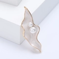 Elegante spilla a foglia dorata con smalto bianco marmorizzato e perle su pietra bianca - Bianco
