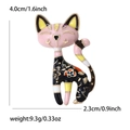 Dettaglio di una spilla a forma di gatto carino in smalto rosa e nero con piccoli fiori - Rosa