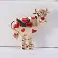 Detail of a golden alloy cow brooch with red enamel hearts and vibrant oil-drop finish - Red