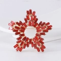 Dettaglio di una spilla a stella con cristalli baguette rossi su base dorata - Rosso