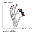 Vintage silver skeleton hand brooch with rhinestones and red drip tip, 4.6cm by 3.1cm - Silver