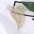 Elegante spilla a fiocco in oro con strass lucidi e lunghe nappe a catena di perline - Oro