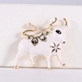 Macro shot of gold-plated ox brooch featuring white enamel and black floral cloud patterns - White
