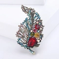 Gedetailleerde close-up van vintage gouden bladbroche met kleurrijke kristallen en strass - Kleurrijk