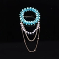 Macro detail of royal blue crystal brooch with pearl tassels and golden chains - Blue